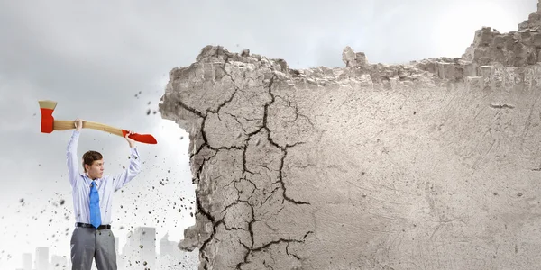 Businessman breaking cement wall — Stock Photo, Image