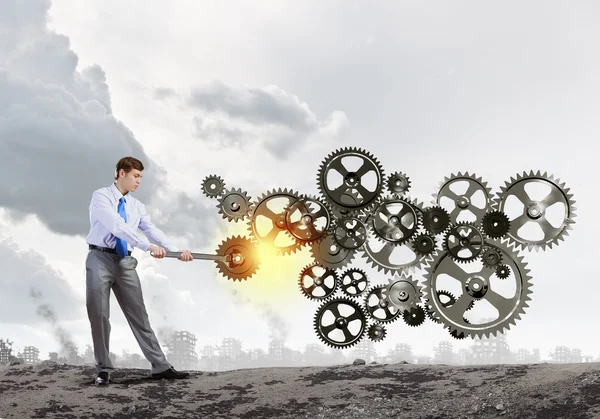 Businessman fixing gears mechanism — Stock Photo, Image