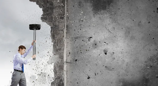 Businessman breaking old wall — Stock Photo, Image