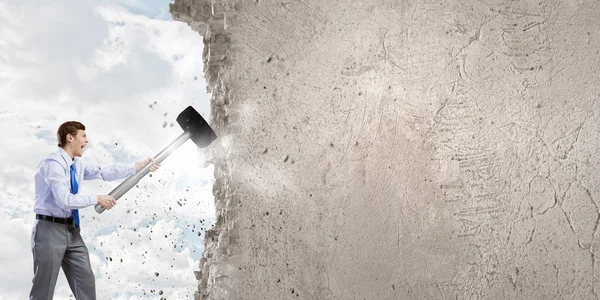 Businessman breaking old wall — Stock Photo, Image