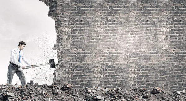 Businessman breaking old wall — Stock Photo, Image