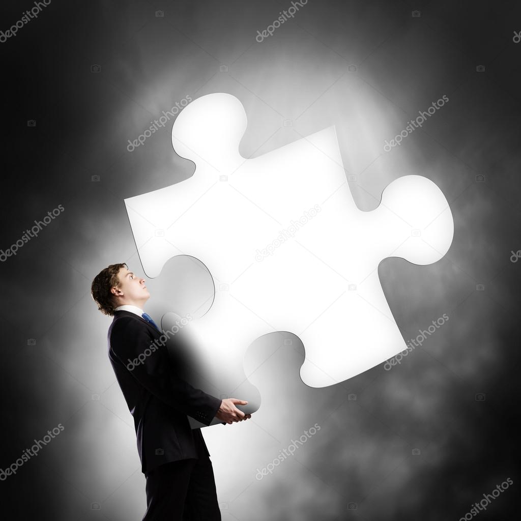 Businessman carrying puzzle piece