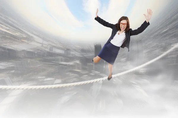 Risky businesswoman balancing on rope — Stock Photo, Image