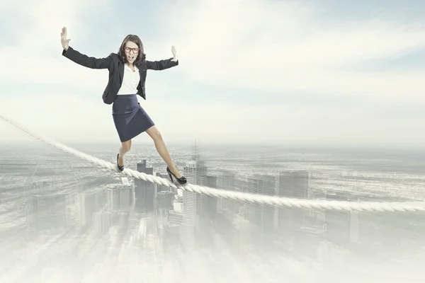 Mujer de negocios arriesgado equilibrio en la cuerda —  Fotos de Stock