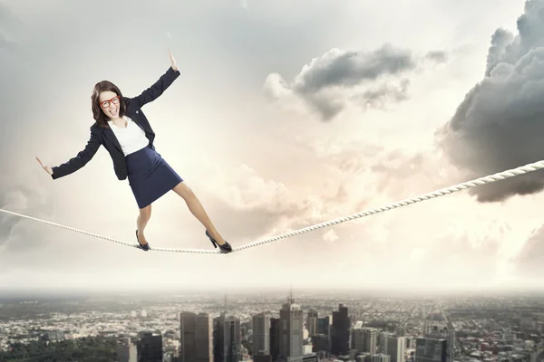 Mujer de negocios arriesgado equilibrio en la cuerda —  Fotos de Stock