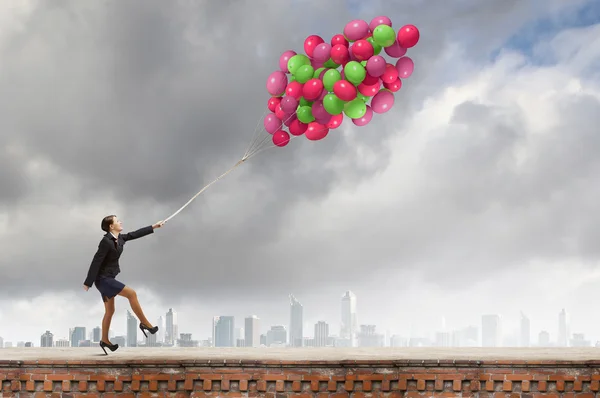 Cheerful businesswoman with balloons — Stock Photo, Image