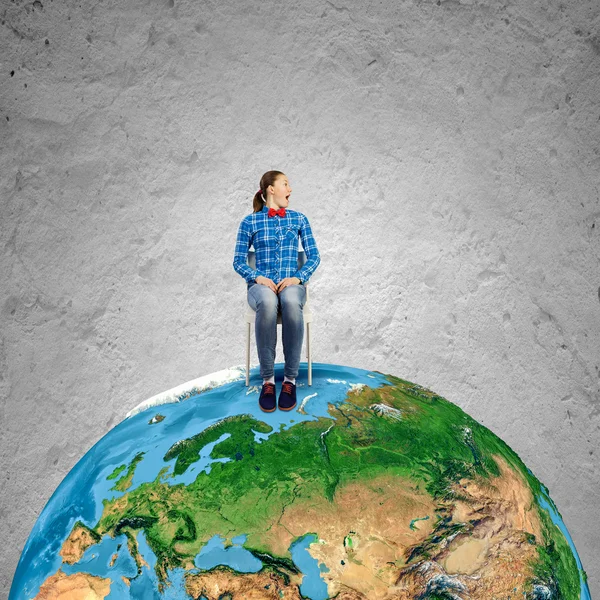 Girl sitting on chair on Earth planet — Stock Photo, Image