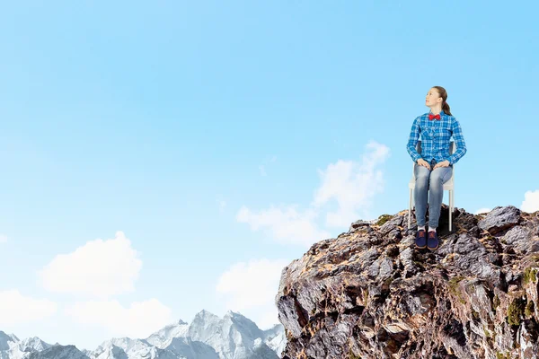 Woman sitting on top of rock — Stock Photo, Image