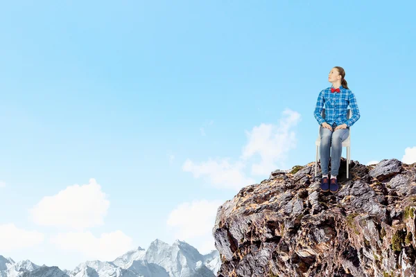 Vrouw zitten op de top van rock — Stockfoto