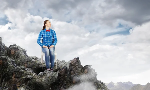 Woman sitting on top of rock — Stock Photo, Image