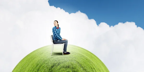 Vrouw zitten in de stoel op groene planeet — Stockfoto