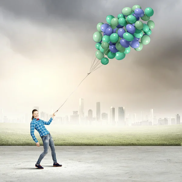 Mujer sosteniendo globos de colores — Foto de Stock