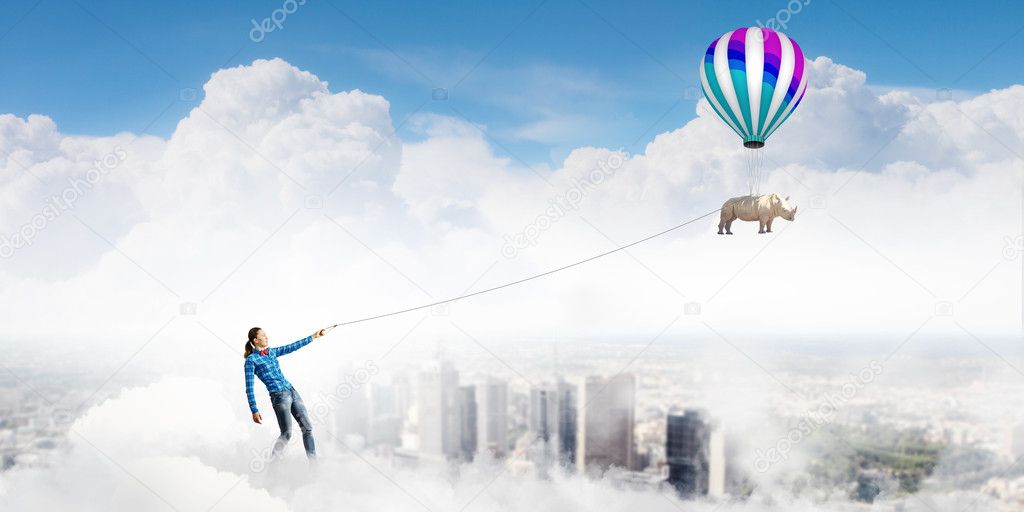 Woman and rhino flying in sky