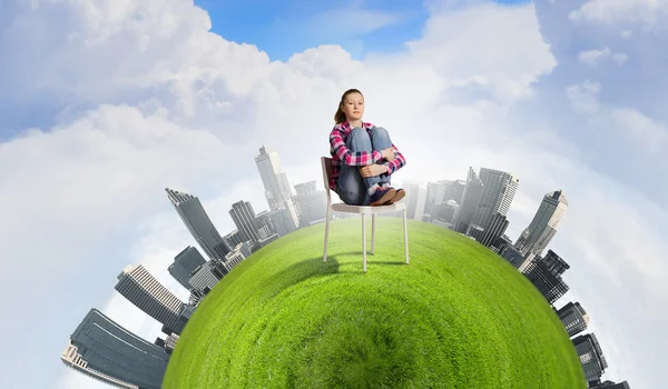Woman sitting on green planet — Stock Photo, Image