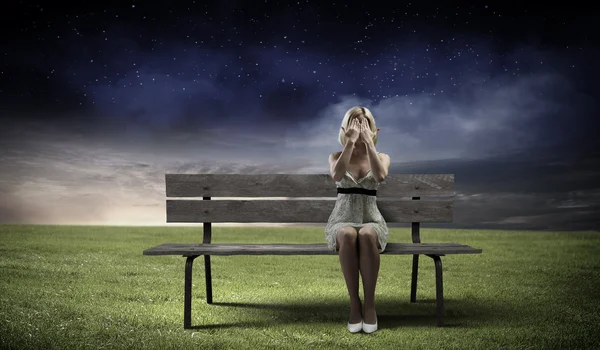 Žena sedí na lavičce — Stock fotografie