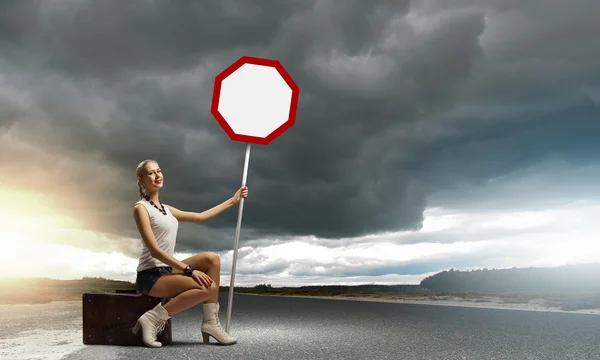 Jeune femme avec panneau de signalisation — Photo