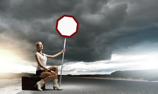 Jeune femme avec panneau de signalisation — Photo