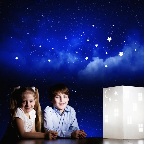 Boy and girl looking at model of house — Stock Photo, Image