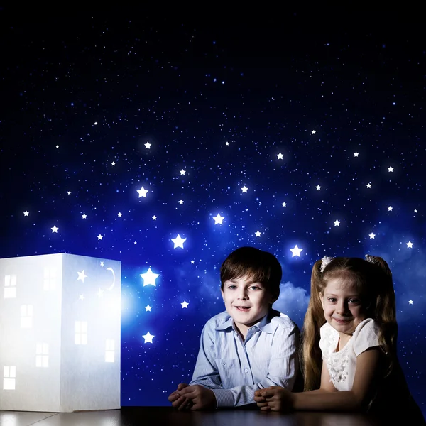 Boy and girl looking at model of house — Stock Photo, Image