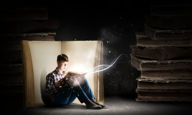 Genç çocuk kitap okuyor.