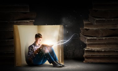 Genç çocuk kitap okuyor.