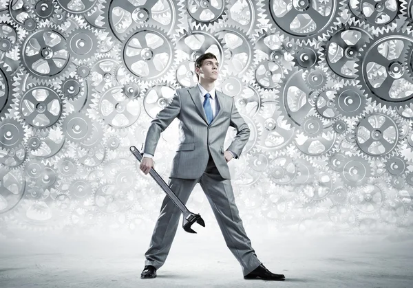 Businessman with wrench and cogwheels — Stock Photo, Image