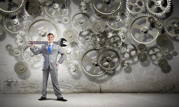 Businessman with wrench and cogwheels — Stock Photo, Image