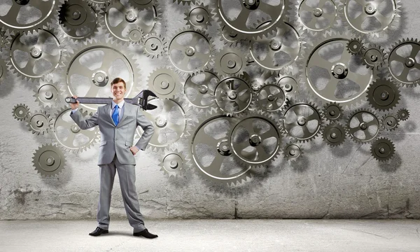 Businessman with wrench and cogwheels — Stock Photo, Image