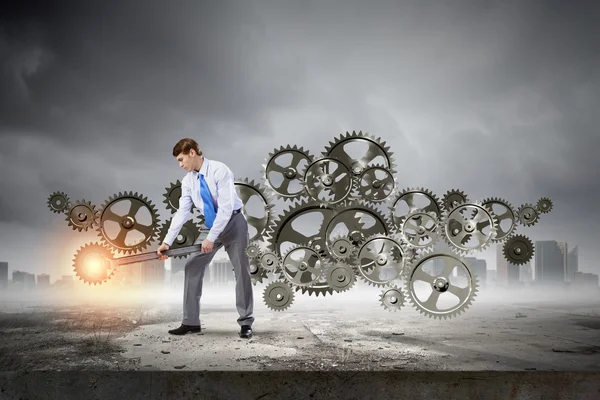 Businessman fixing mechanism — Stock Photo, Image