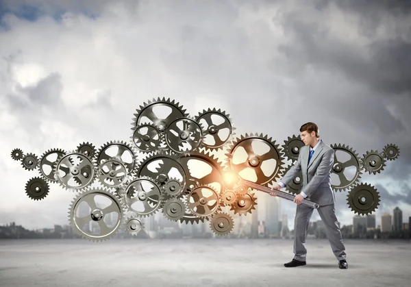 Businessman fixing mechanism — Stock Photo, Image