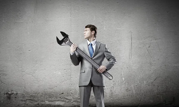 Businessman with wrench — Stock Photo, Image