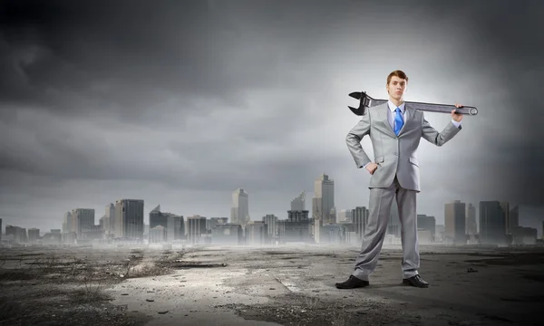 Businessman with wrench — Stock Photo, Image