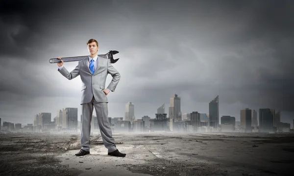 Businessman with wrench — Stock Photo, Image