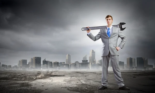 Businessman with wrench — Stock Photo, Image