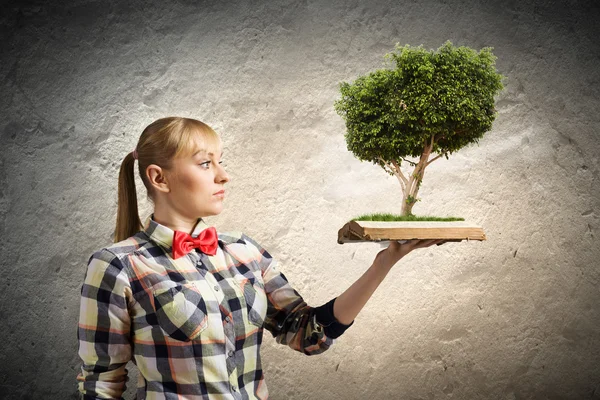 Frau hält Buch mit Baum — Stockfoto