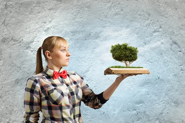 Woman holding book with tree — Stock Photo, Image