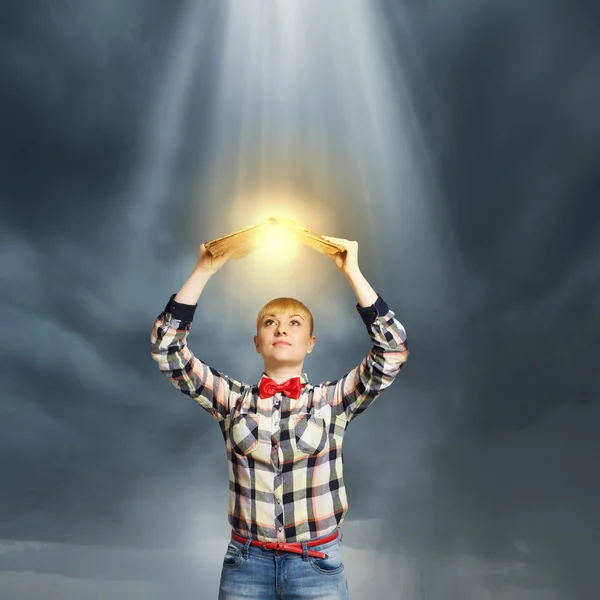 Woman holding book above head — Stock Photo, Image