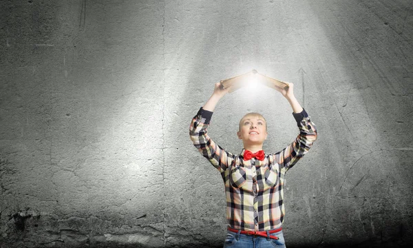 Woman holding book above head — Stock Photo, Image