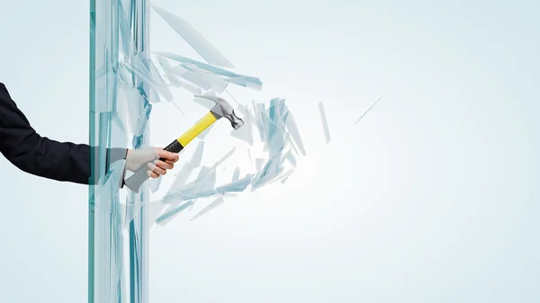 Hand breaking glass with hammer — Stock Photo, Image