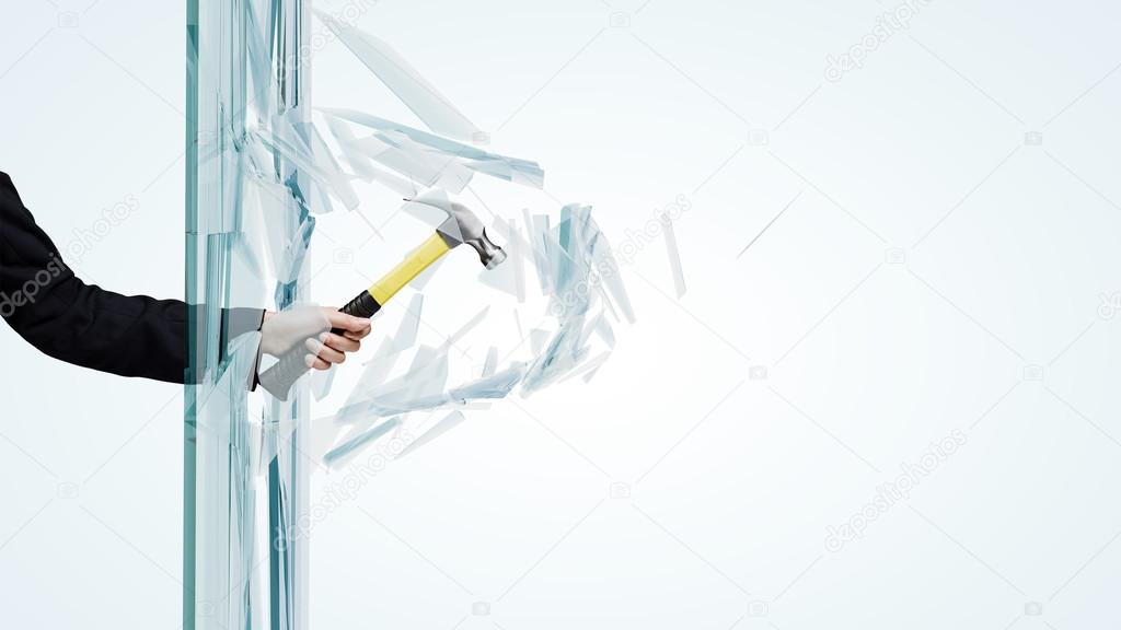 Hand breaking glass with hammer