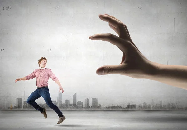 Man running from hand — Stock Photo, Image