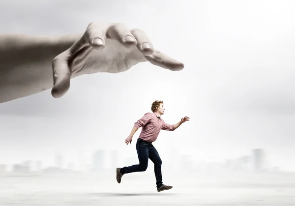 Man running from hand — Stock Photo, Image