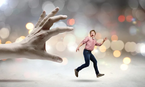 Man running from hand — Stock Photo, Image