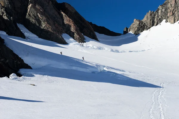 Mensen lopen onder de sneeuw op de bergen — Stockfoto