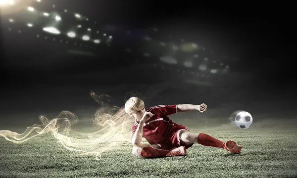 Jogador de futebol fazendo slide tackle — Fotografia de Stock