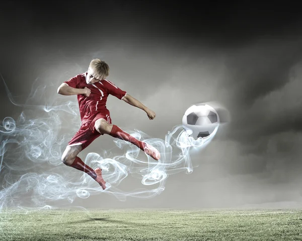 Jogador de futebol chutando bola — Fotografia de Stock