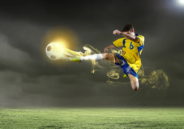 Fotbalový hráč brát míč — Stock fotografie