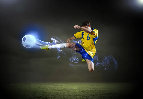 Voetbal speler rekening houdend bal — Stockfoto