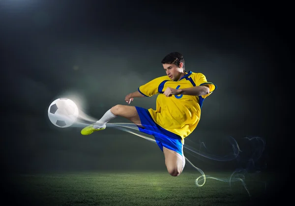 Voetbal speler rekening houdend bal — Stockfoto