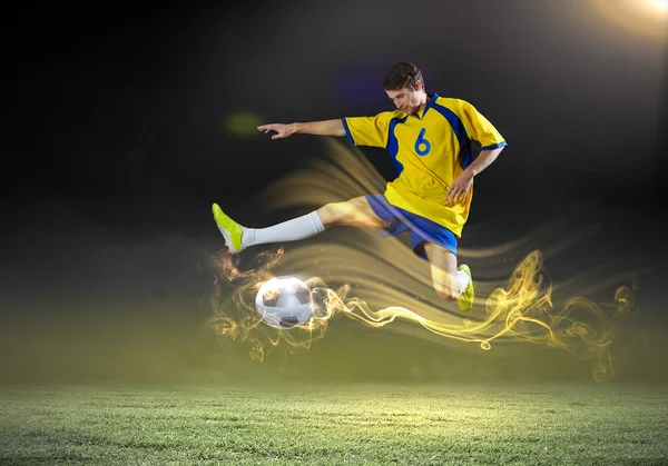 Voetbal speler rekening houdend bal — Stockfoto